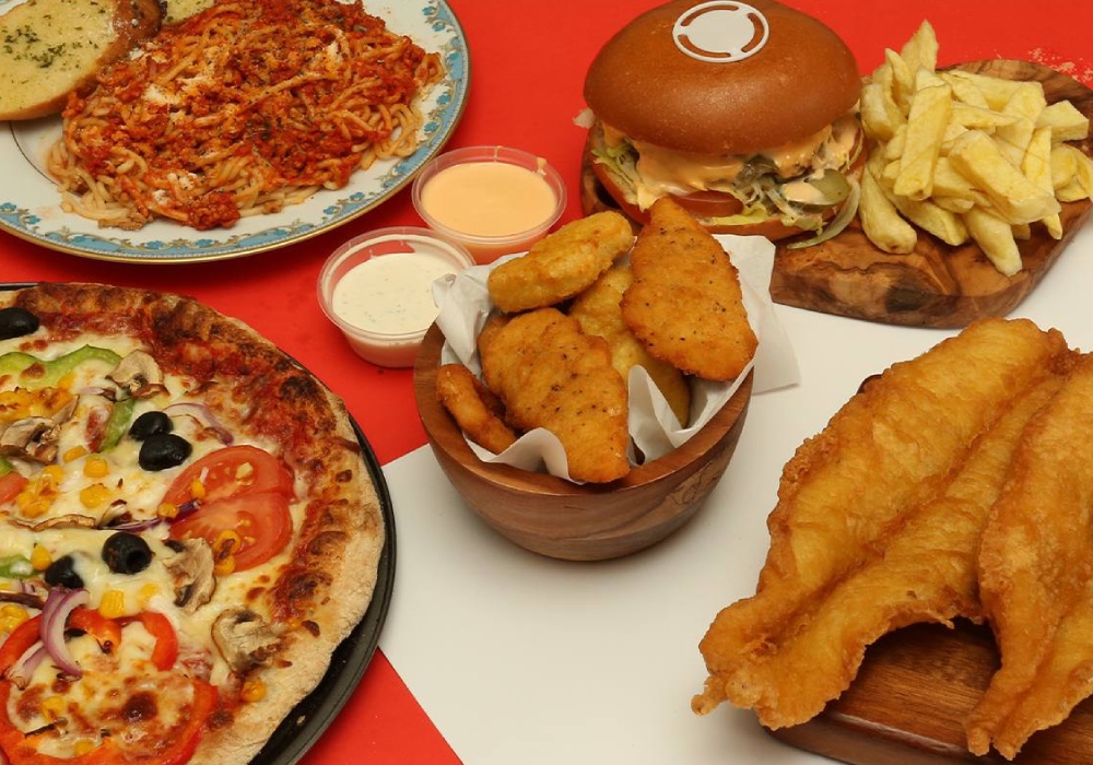 A large Rinaldo's takeaway feast fried fish, nuggets, burger, fries, pasta, and pizza. 